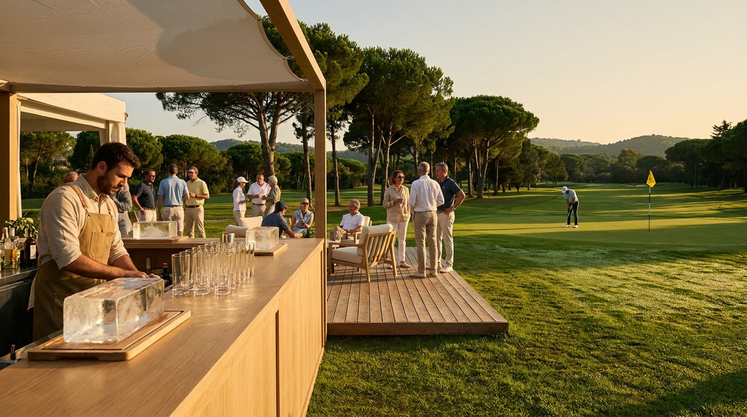 A lounge bar at the edge of a golf green at golden hour, a bartender working beside blocks of clear ice and rows of highball glasses while guests talk on a timber deck and a golfer lines up a putt beneath tall umbrella pines.